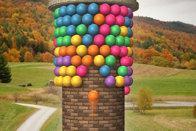 A tower of colored bubbles on a brick column, an autumn landscape behind it